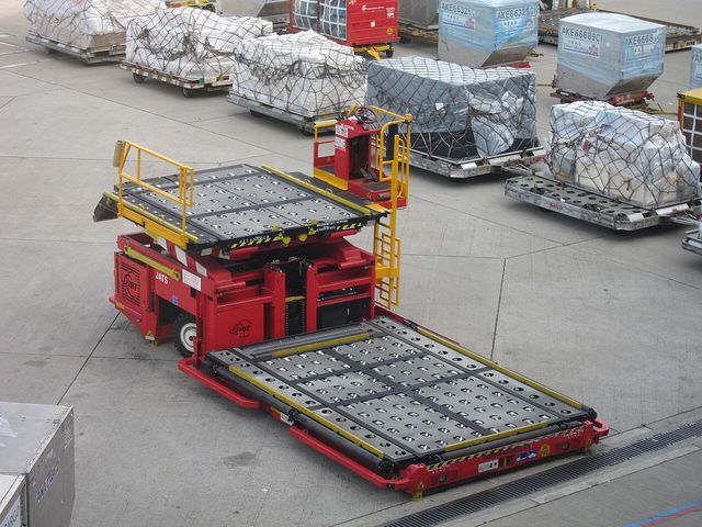 Air cargo pallets and a pallet loader on an airport apron
