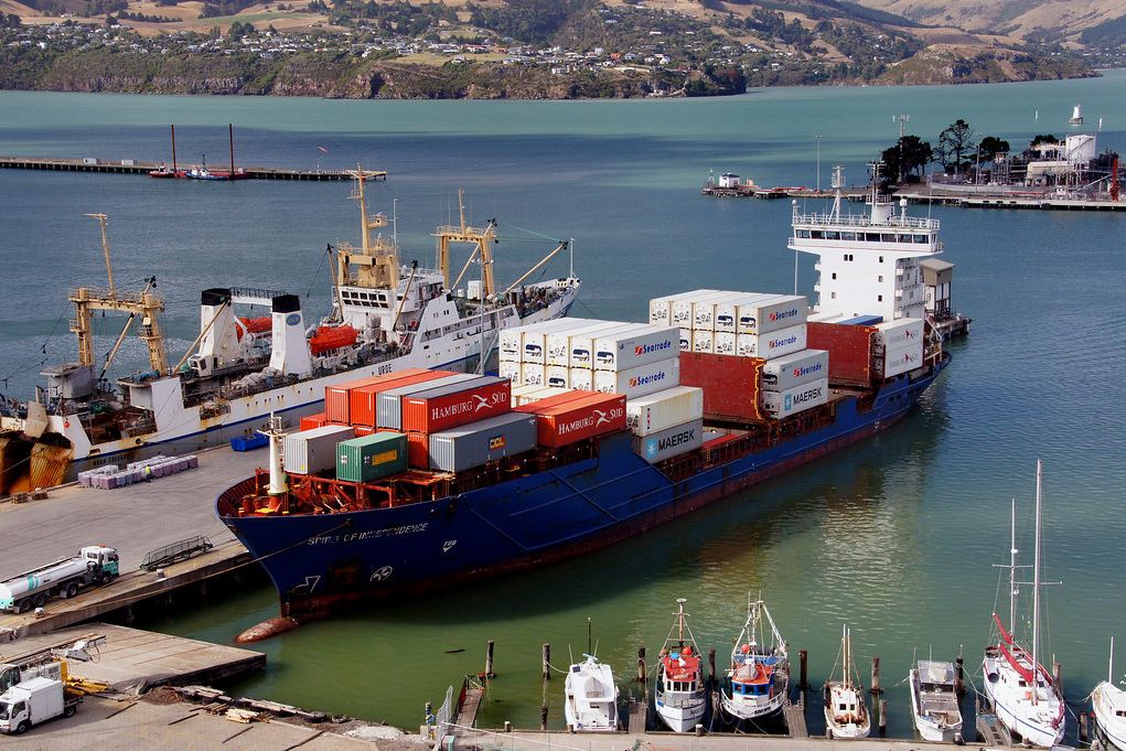 A container ship moored at the Port of Auckland near a marina