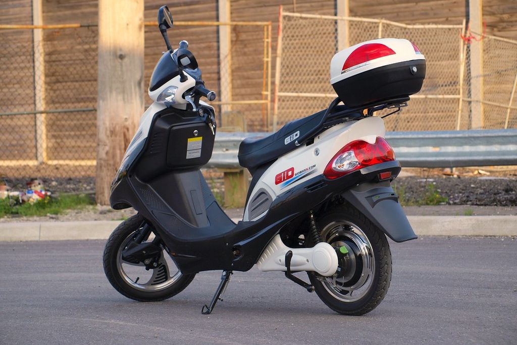 An electric scooter parked by a wall
