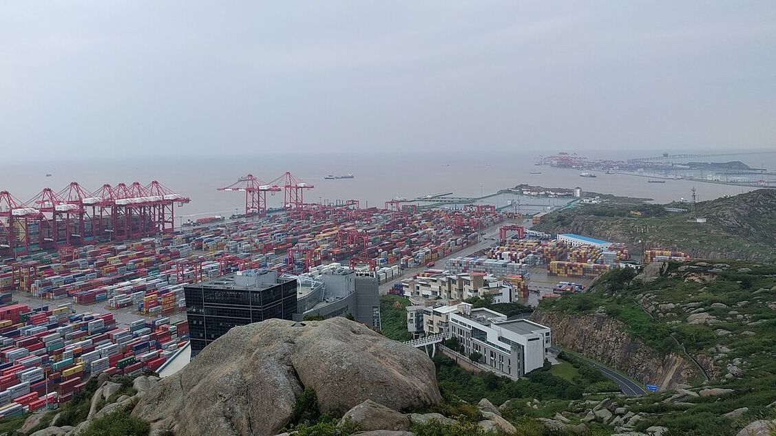 Yangshan deep-water port near Shanghai seen from a hillside, with container stacks and gantry cranes